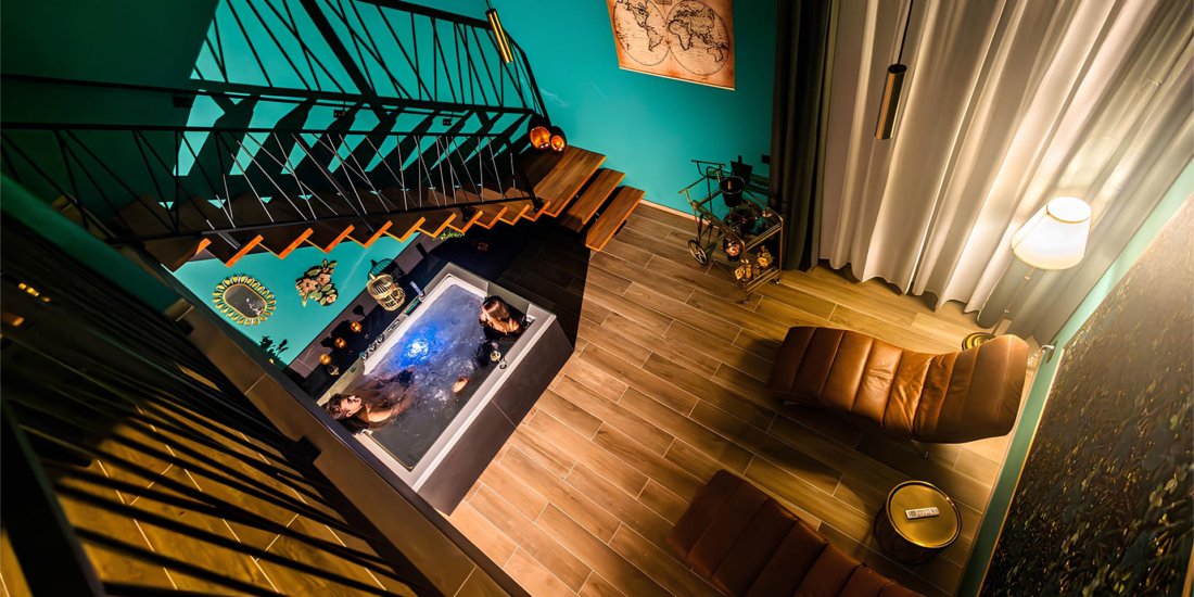 Vue en plongée sur un bain à remous et un espace détente avec chaises longues, dans une ambiance chic et chaleureuse